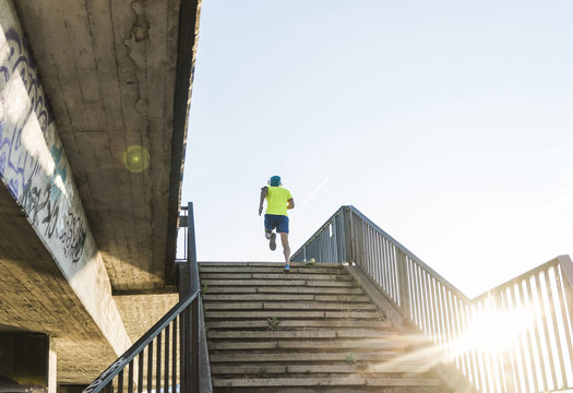 Young athlete jogging up stairs in the city