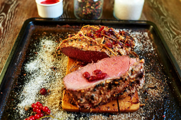 Cook the meat laid out on a baking sheet that apply to the table roasted lamb, all served with bright red berries