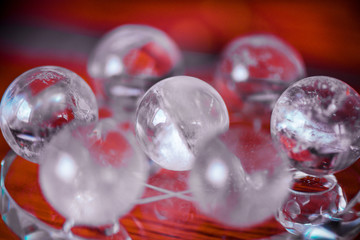 Macro shot of transparent crystal balls with colorful ornaments and sun reflections in it, on turquoise glass pad. Fortune telling. Love, money, luck, success.