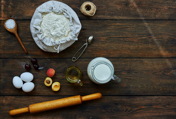 Baking background with copy space. Cooking ingredients for dough and pastry, eggs, flour and butter on dark rustic wood. Homemade baking theme. Top view, mockup for menu, recipe for culinary classes.