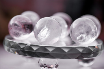Macro shot of transparent crystal balls with colorful ornaments and sun reflections in it, on turquoise glass pad. Fortune telling. Love, money, luck, success.