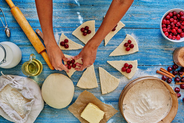 Girl assisent cook gently lay the puff pastry cherries, pitted, after the dough is wrapped