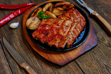 On the table is a cast-iron pan with delicious meat roasted until golden brown