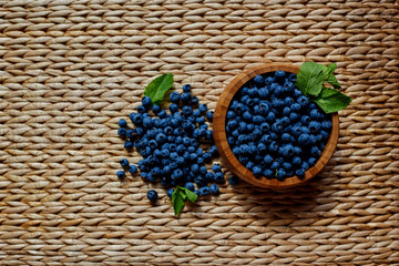 Fototapeta na wymiar Top view of a rattan table is a bowl with fresh blueberries