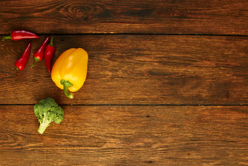 Organic foods. Yellow sweet bell pepper, red chilli and cauliflower on  rustic table.  Healthy meal and vegetarian concept. Ingredients for cooking healthy eating. Food background with copy space..