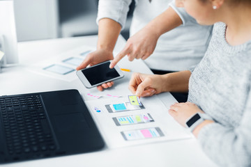 app design, technology and business concept - web designers or developers with smartphone working on user interface at office