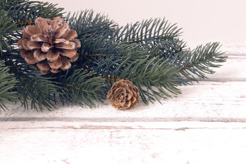 christmas decoration, fir branch with cone on wooden background