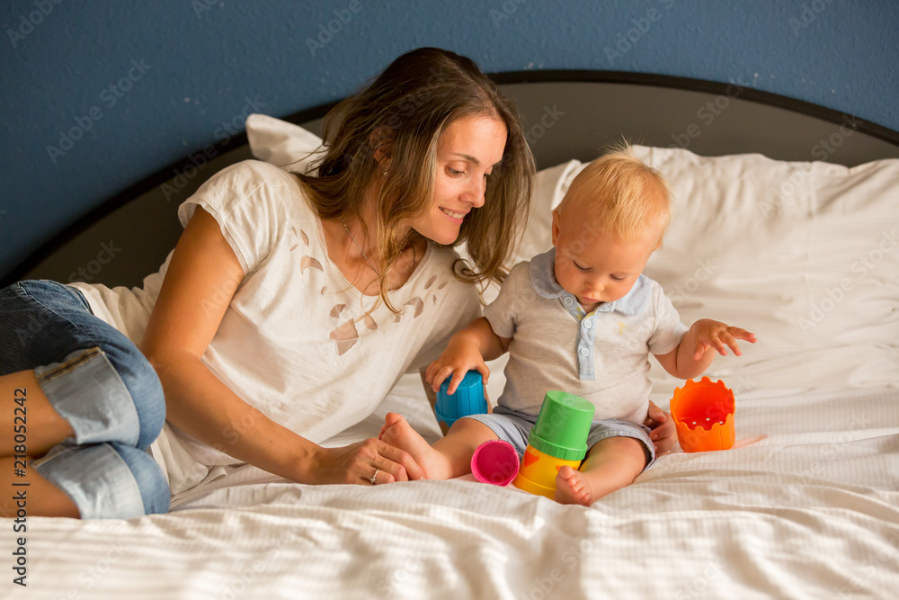 Sticker Mother and baby boy, cute child, playing together in bed with toy