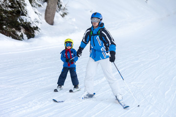 Father and son, preschool child, skiing in austrian ski resort in the mountains