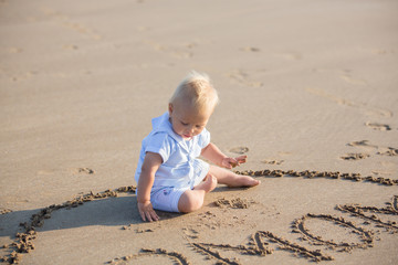 Sweet children, playing on the beach at the ocean on sunset