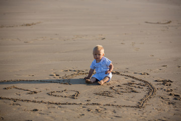Sweet children, playing on the beach at the ocean on sunset