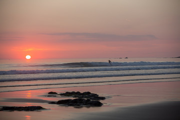 Surfers on the beach on sunset