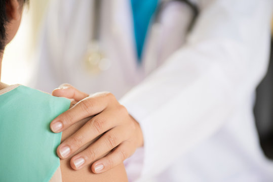 Female Doctor Put Hand On Patient Shoulder For Encouragement And Discussion. Medicine And Health Care Concept. Doctor And Patient.