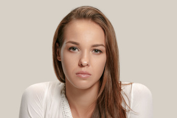 Serious business woman isolated on gray studio background. Beautiful, young face. Female front...