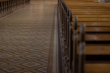 soft focus catholic cathedral church interior inside concept of central way with wooden chairs and brick columns 