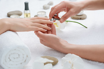 Beauty specialist is eliminating cuticle on a client's hand. Let your nails look nice and fresh.