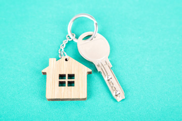A key on a house shaped wooden keychain