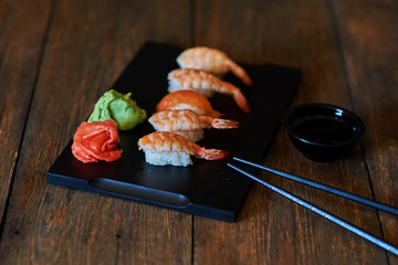 Sashimi sushi set with soy on black background. Close up of sashimi sushi set with chopsticks and...