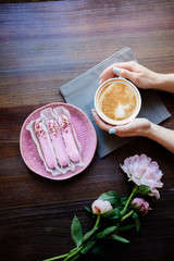 Cappuccino, eclairs and flowers.