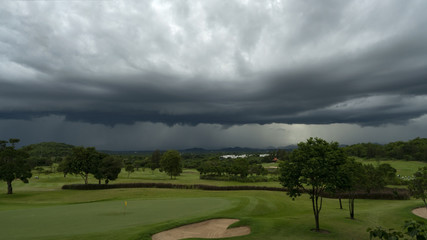 A play on a Hua Hin Thailand golf course is about to end as a sky is already black, a severe storm is approaching. Monsoon season typically brings heavy rains and high winds from Indian Ocean.