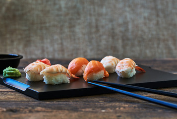 Plate of sushi rolls. Sushi set sashimi and sushi rolls served on wooden plate. Sushi rolls with salmon, eel, tuna, avocado, royal prawn, cream cheese  caviar tobica, chuka. Sushi menu. Japanese food.