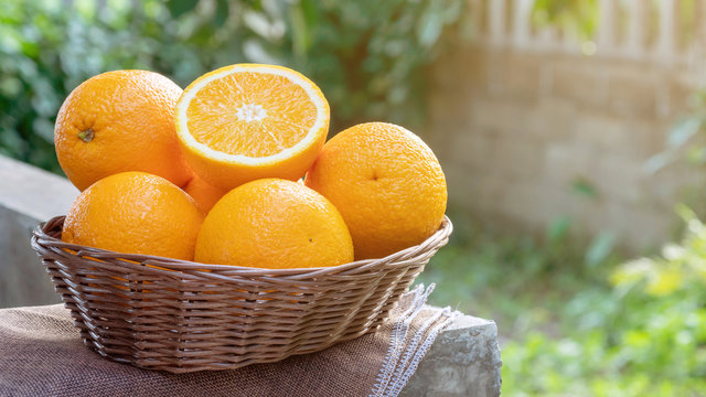 Fototapeta Oranges fruit in a basket on nature background.