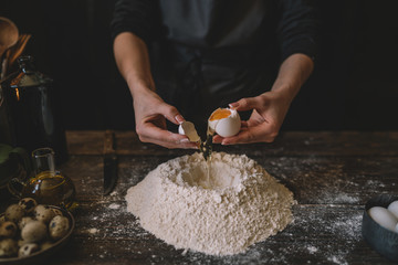 Food, cooking and baking concept. Making dough by female hands at bakery. Dough background....