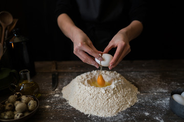 Woman cracking egg for dough. Retro styled imagery. Making dough. Cooking ingredients for pastry on...