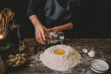 Foto op Canvas Hands working with dough preparation recipe bread, pizza or pie making ingridients, food flat lay on kitchen table background. Butter, milk, yeast, flour, eggs, pastry or bakery cooking. © eskstock