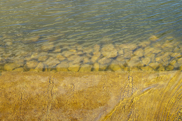 Texture of water beside coast with stone