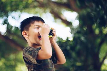 Asian child taking a picture with camera