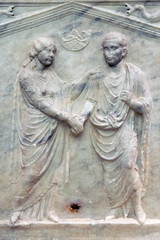 Fototapeta na wymiar Bas-relief of an ancient Roman sarcophagus depicting a woman and her husband in the the public Baths of Diocletian in Rome, Italy. It was built from 298 to 306