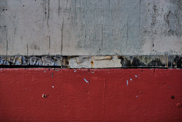 Old painted surface. Dark plaster wall with dirty white and red paint with black scratches.  Retro vintage worn wall. Decayed cracked rough abstract banner surface.