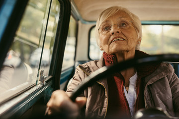 Senior female driving a vintage car