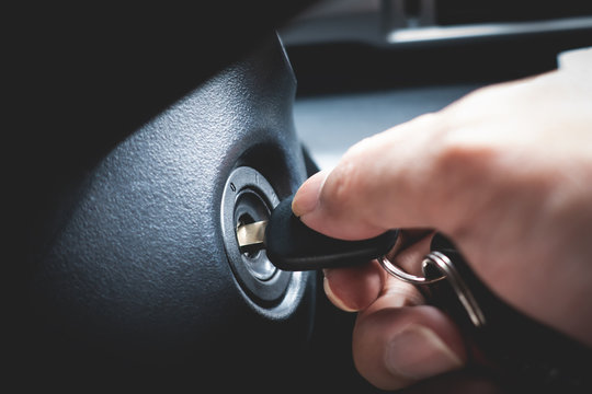 Hand Turning Car Key In The Key Hole To Start The Car Engine