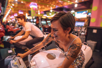 Woman riding an arcade racing bike