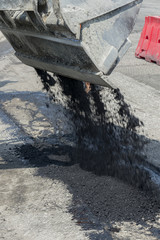 The process of asphalting roads. Machinery for asphalting roads. vertical photo