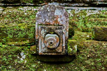 Architectural detail covered with moss in the ancient stone temple in the Balinese jungle.