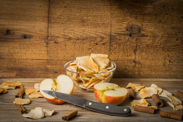 Dried apple slices on the wooden table close up