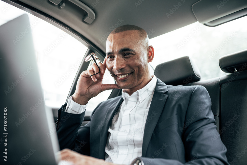 Wall mural businessman looking at laptop sitting in car