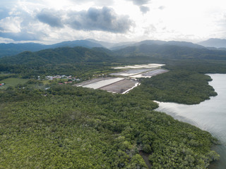 Local Shrimp farm in Paquera Costa Rica surrounded by lush green mountains and the Gulf of Nicoya as seen from an aerial drone