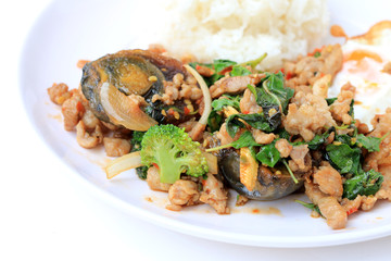 Stir-fried basil leave with minced pork, chicken, fried preserved egg and carrot, yellow corn, Broccoli with rice and fried egg in white dish on white background. Thai style food.