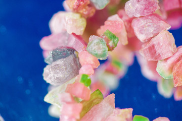 Macro shot of watermelon tourmaline crystals in necklace. Natural, rough, unpolished stones. Beautiful, pink and green gemstones on blue background
