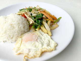 Stir mix vegetables  with gravy sauce and thai style fried egg in white plate on white background. Vegetarian Food, healthy food.