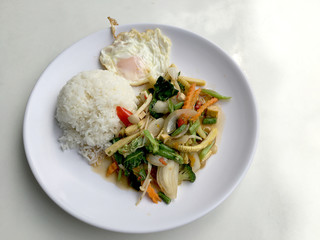 Stir mix vegetables  with gravy sauce and thai style fried egg in white plate on white background. Vegetarian Food, healthy food.