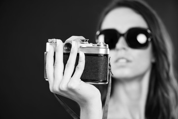 cute brunette girl holding an old camera in hands
