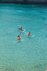 Three friends on a red kayaks in the sea