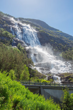 The Langfossen falling into the fjord with the main road in front of it