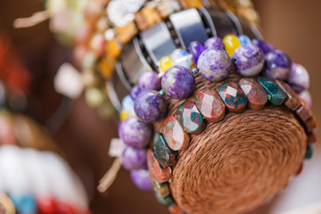 Gemstone bracelets and necklaces in a row. Jewelry made of heliotrope stone and sugilite blue stone. Healing, powerful crystal energy. Esoteric and colorful background
