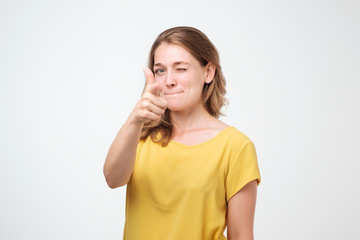Young beautiful woman pointing at you, isolated over white background.